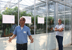 Ary de Jong of HortiTech explaining autonomous growing. In the background Ronald Groen of Looije Agro Technics subjecting the greenhouse roof to a brief inspection.